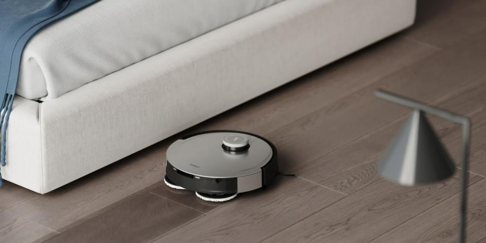 A robot vacuum and mop by a sofa in a living room