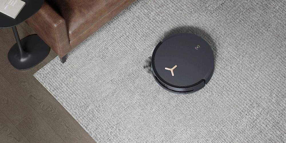 A robot vacuum cleaning on a light gray carpet