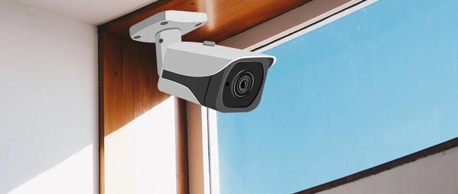 A security camera mounted on an indoor window frame aimed outside